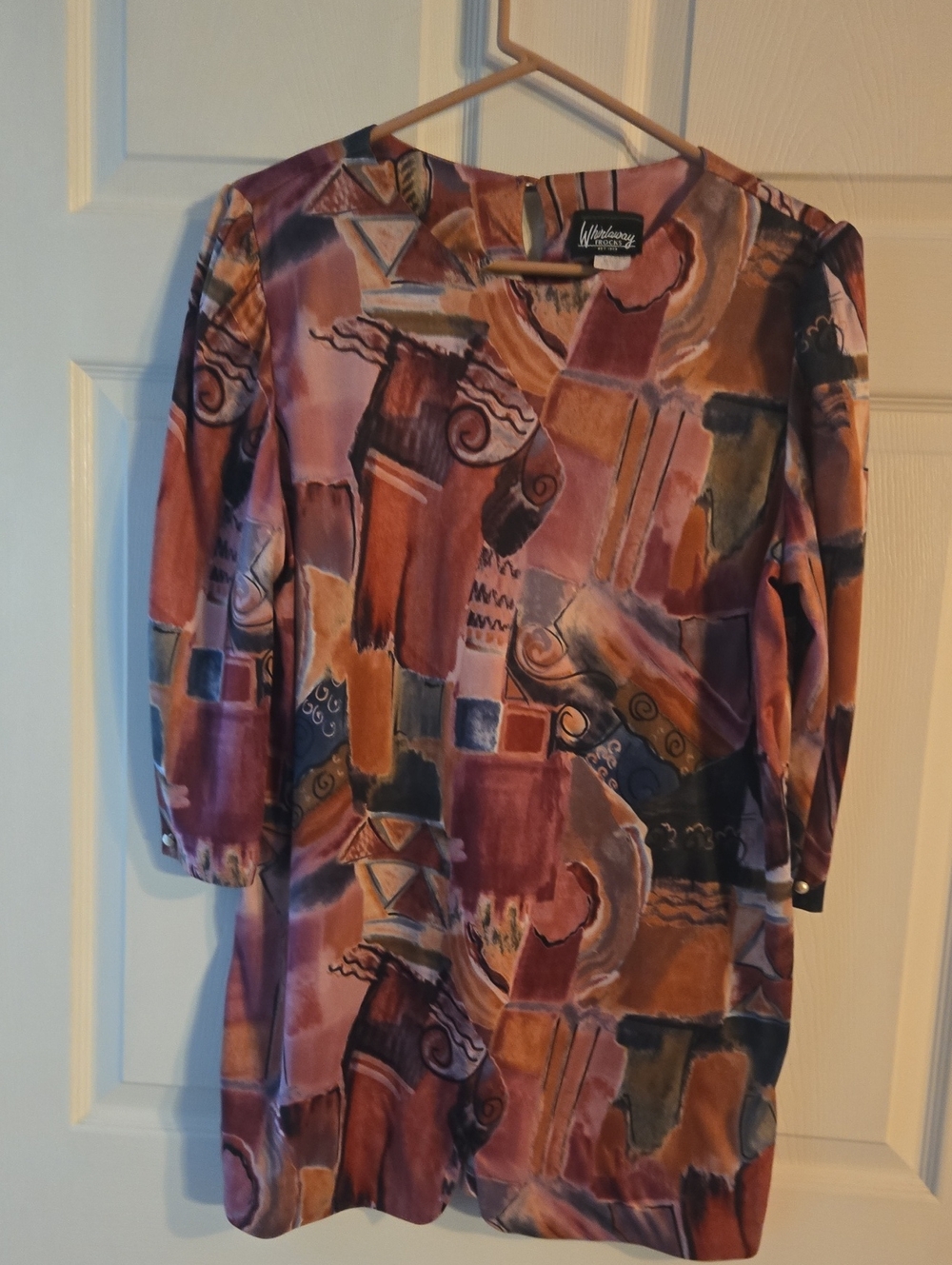 Whirlaway Frocks label on rust and black patterned fabric